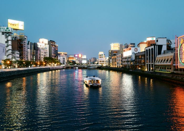 A boat traveling down the Fukuoka Naka river at sunset.